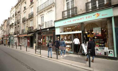 rue avec passants masqués devant une librairie ouverte
